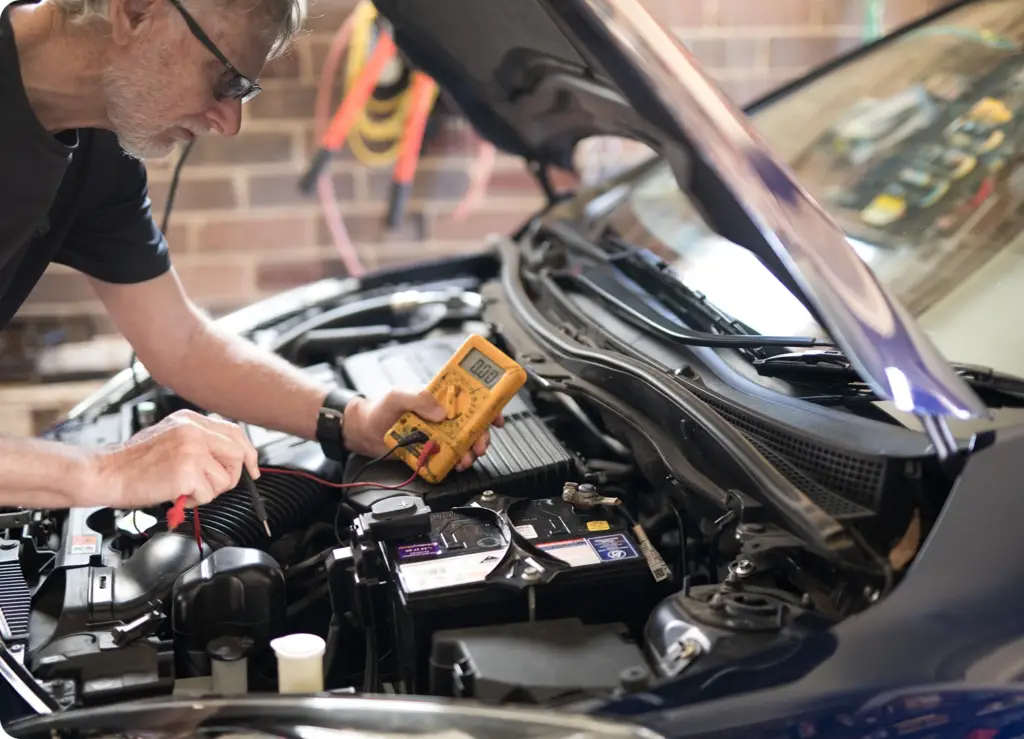 7 Essential Car Services You Can Book From Your Phone An image of a mobile mechanic testing a battery-on-demand car service by Revilo Auto Care