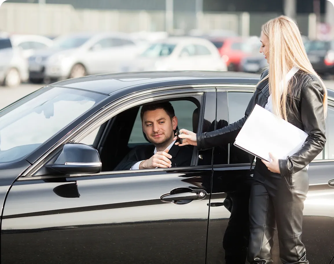 A man receiving the key to a rental car after booking service through Revilo Auto Care